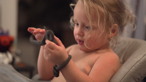Funny-little-girl-trying-to-make-playdough-bracelets