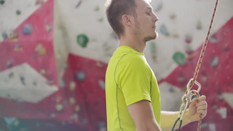 Man-belaying-another-climber-on-an-indoor-climbing-wall.-A-man-using-insurance-climbers-holds-the-rope-and-insures-his-partner-who-climbs-the-mountain