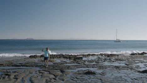 Niño-Caminando-Por-La-Playa-De-Arena-Negra-De-Lanzarote,-Islas-Canarias.