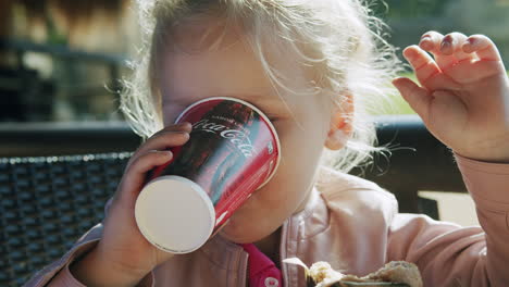 Kleines-Kind-Beendet-Das-Mittagessen-Mit-Einer-Tasse-Coca-Cola