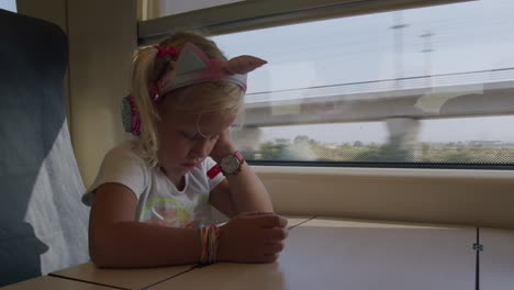 Little-traveler-watching-cartoons-on-the-phone-in-train