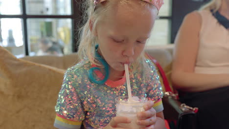 Kid-drinking-delicious-milkshake-in-cafe