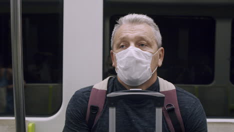 Senior-man-in-mask-traveling-by-subway
