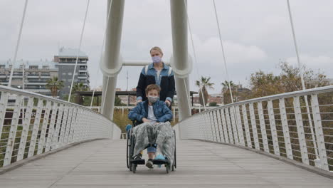 Mother-walking-with-son-in-wheelchair