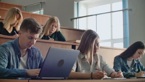 Large-Group-of-Multi-Ethnic-Students-Working-on-the-Laptops-while-Listening-to-a-Lecture-in-the-Modern-Classroom.-Bright-Young-People-Study-at-University.