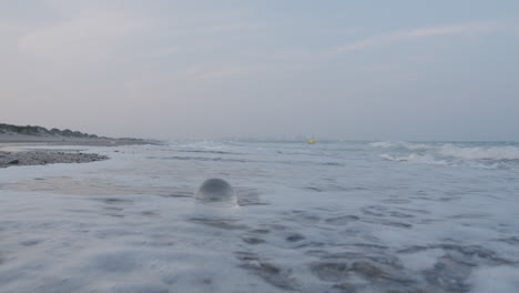Sea-waves-washing-the-shore-with-glass-orb