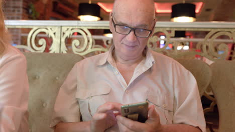 Hombre-Mayor-Con-Teléfono-En-El-Restaurante