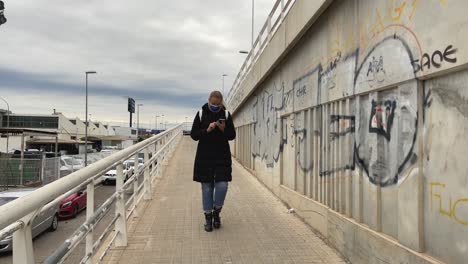 Mujer-Caminando-En-Un-Distrito-De-La-Ciudad-Salpicado-De-Graffiti