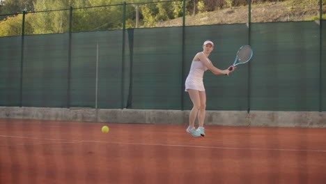 Female-tennis-player-on-the-court-strikes-a-flying-ball-a-dynamic-game-of-tennis-on-the-open-court