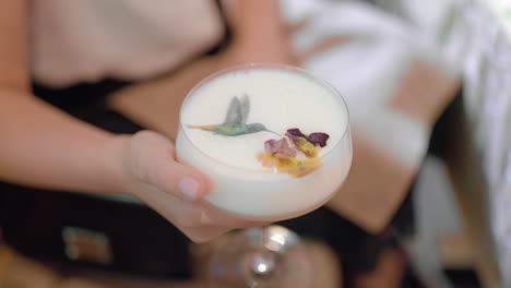 Cocktail-with-elegant-decor-in-female-hands