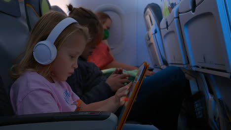 Kinder-Mit-Gadgets-Und-Schlafende-Mutter-Im-Flugzeug