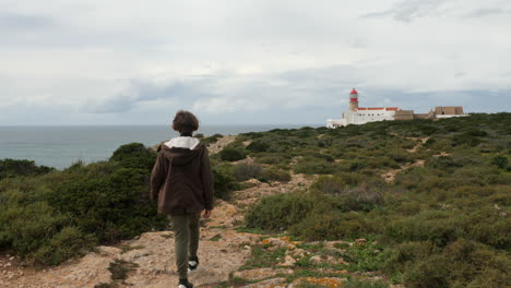 Boy-traveler-walking-to-Cape-St-Vincent-Lighthouse-in-Portugal