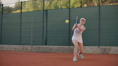 Professional-equipped-female-beating-hard-the-tennis-ball-with-tennis-racquet.-Professional-equipped-female-beating-hard-the-tennis-ball-with-tennis-racquet