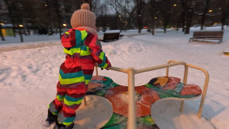 Glückliches-Kleines-Mädchen-Am-Kreisverkehr-Auf-Dem-Spielplatz-Winterspaß
