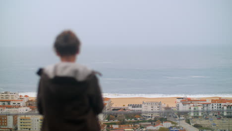 Teenager-Junge-Blickt-Vom-Hotel-An-Der-Küste-In-Nazare,-Portugal,-Auf-Das-Meer