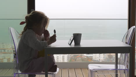 Kleines-Kind-Wartet-Auf-Das-Frühstück-Und-Schaut-Sich-Videos-Am-Telefon-An