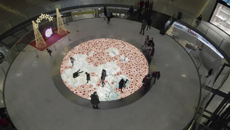 Children-having-fun-on-interactive-floor-screen-with-flowers-in-trade-centre