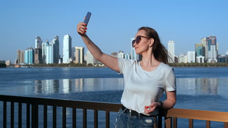 Outdoor-portrait-of-young-attractive-female-in-stylish-outfit-making-a-selfie.-Phone-camera-POV