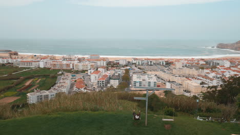 Junge-Schwingt-Und-Beobachtet-Den-Küstenort-Nazare-In-Portugal