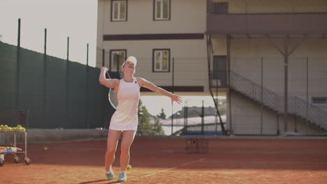 Young-pretty-girl-plays-tennis.-A-woman-in-a-white-tracksuit-professionally-trains-tennis.-Young-pretty-girl-plays-tennis.-tennis-supply