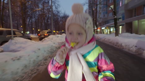 Happy-child-running-in-winter-city-in-the-dusk