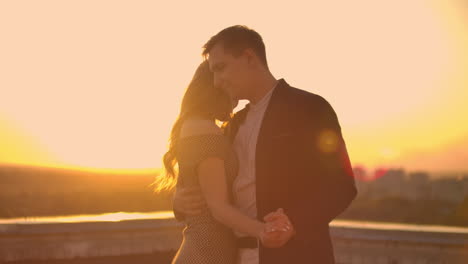Two-lovers-dance-together-on-the-roof-at-sunset-in-the-sunlight.-Romantic-dancing