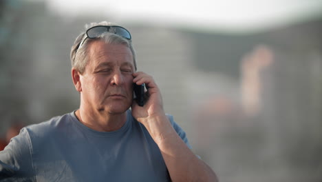 Retired-man-talking-on-the-phone-outdoors