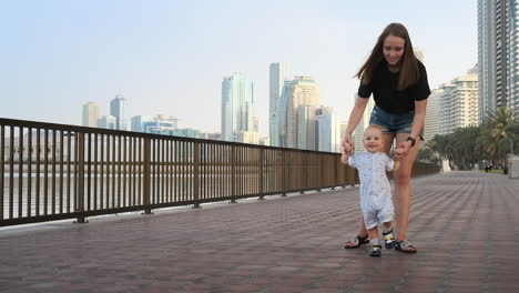 In-the-summer-a-young-mother-walking-with-a-child-along-the-promenade.