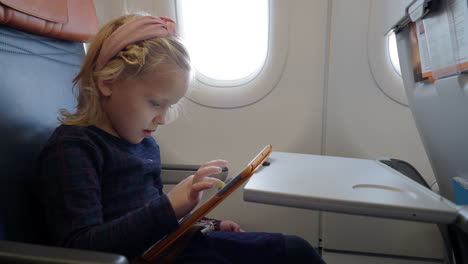 Kind-Benutzt-Tablet-Computer,-Um-Im-Flugzeug-Zu-Zeichnen