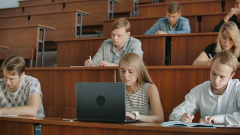 Large-Group-of-Multi-Ethnic-Students-Working-on-the-Laptops-while-Listening-to-a-Lecture-in-the-Modern-Classroom.-Bright-Young-People-Study-at-University.