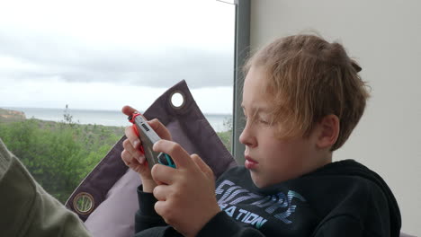 Boy-teenager-with-portable-game-console-at-home