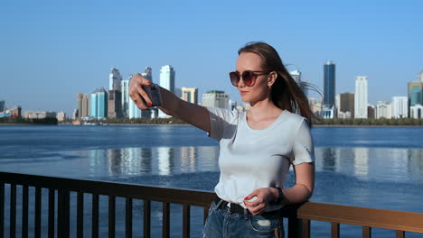 Una-Mujer-Caucásica-Está-Tomando-Selfies-Por-Teléfono-Móvil-Al-Aire-Libre-En-El-Puerto-Deportivo-De-Dubai-En-Un-Día-Soleado.