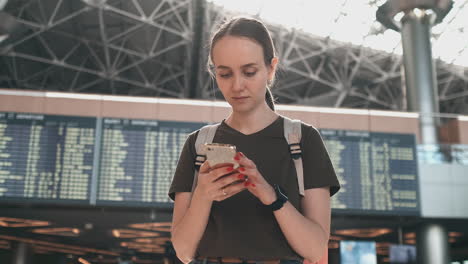 A-young-woman-is-online-check-in-to-Board-the-plane.-Booking-a-car-through-the-smartphone-app.-Car-sharing-services-from-your-smartphone.-Hotel-reservation-via-phone
