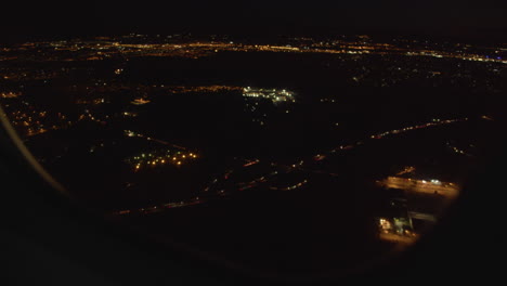 Blick-Auf-Die-Stadt-Bei-Nacht-Aus-Dem-Fenster-Eines-Passagierflugzeugs