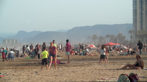Scenic-beach-full-of-people-relaxing-and-playing-tennis