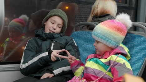 Sister-with-elder-brother-playing-rock-scissors-paper-in-the-bus