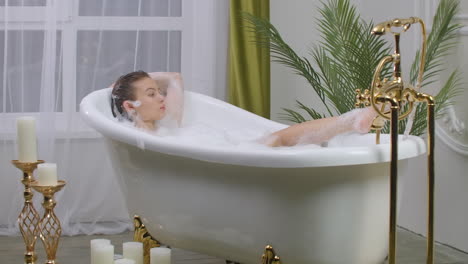 Beautiful-woman-relaxing-in-bubble-bath-lying-in-bathtub.-Beauty-care-leisure-activity-and-healthcare-concept.