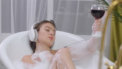 Listen-to-music-in-the-bath-and-drink-wine-relax-and-unwind-in-the-lying-bubble-bath.-Take-a-bath-after-a-hard-week.-Recuperate.