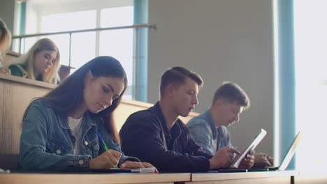 Hochschulproduktion-Vor-Großem-Publikum-Studierende-Schreiben-In-Die-Vorlesungshefte-Und-Laptops.