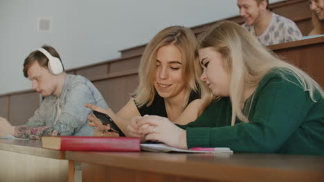 Cheerful-students-are-using-smartphones-and-chatting-during-break-between-lectures-at-university.-Modern-technology.-Cheerful-students-multiethnic-group-are