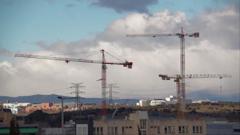 Urban-Landscape-with-Construction-Cranes-and-Mountains