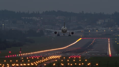 Long-shot-of-airplane-landing-at-dusk