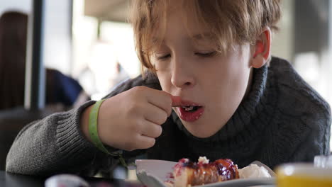 Boy-eating-berry-pie-for-dessert-in-cafe