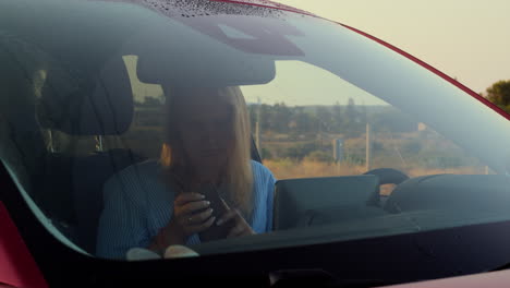 Female-car-driver-with-phone-in-the-countryside
