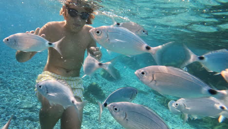 Teenager-underwater-surrounded-by-fish