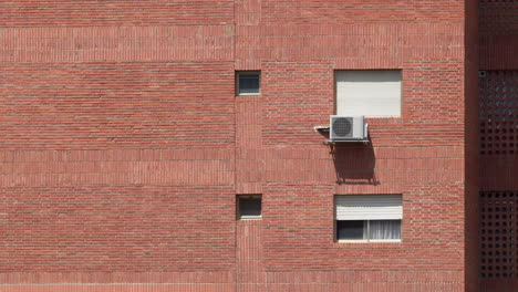 Brick-building-wall-with-windows-and-air-conditioner