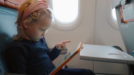 Child-using-digital-tablet-in-the-airplane
