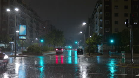 Nächtliches-Stadtbild-Im-Regen,-Wenige-Autos-Auf-Den-Nassen-Straßen