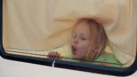 Kleines-Mädchen-Zeichnet-Herz-Auf-Fenster-In-Einem-Lieferwagen