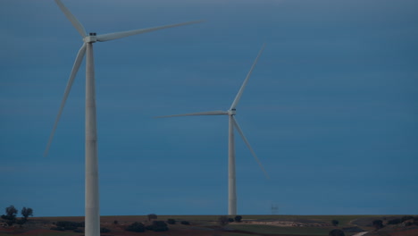 Two-windmills-in-evening-field